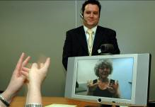 A Video Relay Service session helping a deaf person communicate with a hearing person via a video interpreter (sign language interpreter) and a videophone A Video Relay Service session helping a deaf person communicate with a hearing person via a video interpreter (sign language interpreter) and a videophone